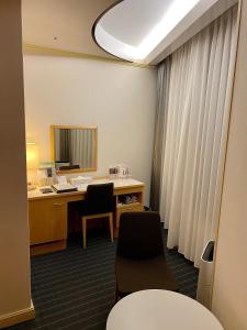 岐阜市にあるホテルグランヴェール岐山のデスクと椅子2脚、窓のあるオフィス