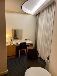 ein Büro mit einem Schreibtisch, 2 Stühlen und einem Fenster in der Unterkunft Hotel Grand Vert Gizan in Gifu