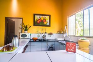 a kitchen with yellow walls and a counter top at Casa Vilar Rio Temporada Barreirinhas Lencois Maranhenses in Barreirinhas