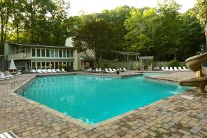 a swimming pool with chairs and a house at Bear Sightings! 8 mins to downtown Gatlinburg, Kids Cave, Theatre, Treehouse! in Gatlinburg