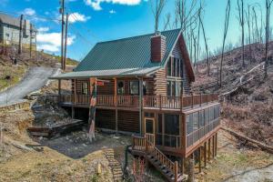 a log cabin with a deck in the woods at Bear Sightings! 8 mins to downtown Gatlinburg, Kids Cave, Theatre, Treehouse! in Gatlinburg