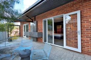 - une terrasse avec 2 chaises bleues et un bâtiment dans l'établissement Riverview on Mount Street, à Perth