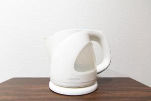 a white coffee mug sitting on a wooden table at RUMa INN Rokugoudote in Tokyo