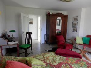 ein Wohnzimmer mit roten und grünen Stühlen und einem Schreibtisch in der Unterkunft Rosalee in Strehlow