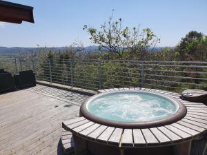 a hot tub sitting on top of a wooden deck at Suite Nid d'Amour et Spa privatif in Vogüé