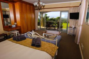 a hotel room with a bed and a large window at On The Cliff Guest House in Hermanus