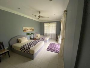 J Guest House في Kuala Penyu: غرفة نوم بسريرين ومروحة سقف