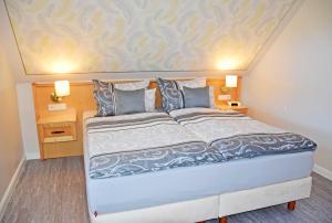 a large bed in a room with two night stands at Ferienappartements am Granitzwald in Ostseebad Sellin