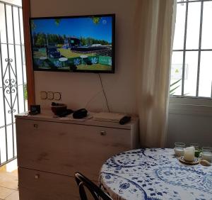 a room with a table and a television on a wall at La Cala sunny rooftop in Mijas Costa