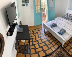 een slaapkamer met een bed en een tafel met een laptop bij GuestHouse COMFY - separate rooms in the apartment for a relaxing holiday in Haifa
