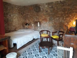 a bedroom with a bed and two chairs and a table at Caraussane caractère terrasse sur jardin et wifi via fibre en coeur de ville in Sète