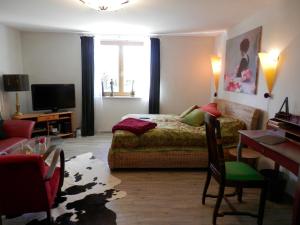 Schlafzimmer mit einem Bett, einem Schreibtisch und einem TV in der Unterkunft Rosalee in Strehlow