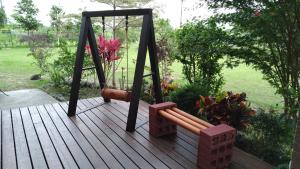 a wooden deck with a swing and a bench at Celine's B&B in Fenglin