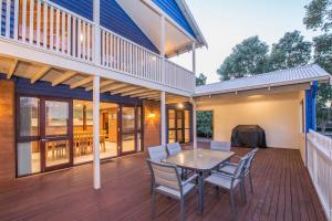 a deck with a table and chairs on a house at Ultramarine in Dunsborough