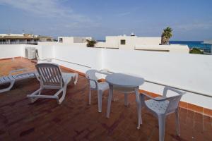 un patio con sillas y una mesa en el techo en Apartamentos Pou Des Pujols en Es Pujols