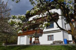 Una casa blanca con un árbol delante. en apart-berg-zeit, en Kauns