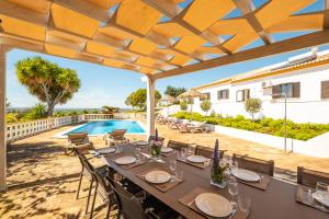 uma área de refeições exterior com uma mesa e cadeiras e uma piscina em Casa Katarina - Private Villa - Heated pool - Free Wifi - Air Con em Tunes