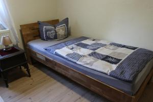 a bed with a blue and white quilt on it at Ferienwohnungen Kleiner Kuhstall in Kurort Gohrisch