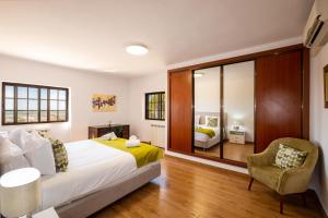 een slaapkamer met een groot bed en een stoel bij Casa Katarina - Private Villa - Heated pool - Free Wifi - Air Con in Tunes +32 foto's