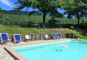 - une piscine avec des chaises et un flotteur dans l'eau dans l'établissement Podere San Giuseppe Maremma, à Castelnuovo di Val di Cecina