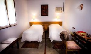 a room with two beds and a bench and a window at Golden Lodge in Paso de la Patria