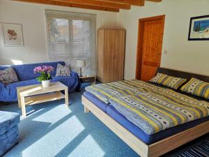 a bedroom with a blue bed and a blue couch at Sinnglück in Obersinn
