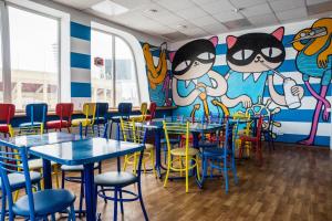 a restaurant with tables and chairs and a mural at Aqua Hostel in Saint Petersburg