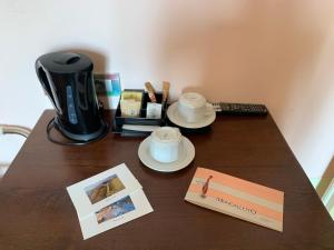einen Tisch mit Kaffeemaschine und ein Buch darauf in der Unterkunft Mongalletto in Castellinaldo