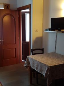 a room with a table and a door and a television at Da Petro Appartamenti per vacanze in Pila
