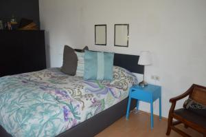 a bedroom with a bed with a blue night stand and a table at Box58 in Eisenstadt