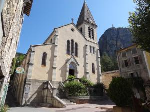 a church with a tower and a steeple at Résidence de l'Escoulaou in Castellane