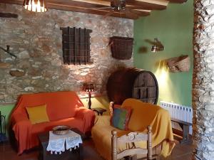a living room with two chairs and a stone wall at La Mallada in Sant Jordi +43 photos