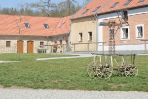 a wooden cart sitting in the grass next to a building at Statek Krkavčí Hora in Nižbor