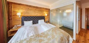 a bedroom with a large bed with a wooden wall at Landhaus Ramsau in Ramsau am Dachstein