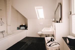 biała łazienka z umywalką i toaletą w obiekcie Ferienwohnung am Berg w mieście Lengerich