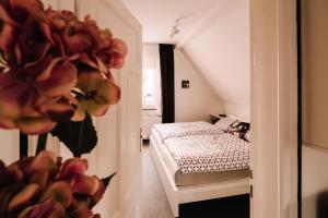 a small bedroom with a bed and a flower at Ferienwohnung am Berg in Lengerich