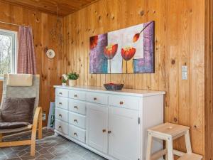 een wit dressoir in een kamer met een schilderij aan de muur bij 6 person holiday home in Fan in Fanø