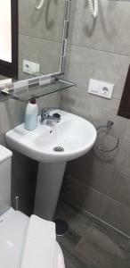 y baño con lavabo blanco y espejo. en Pensión La Montoreña, en Sevilla