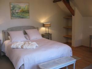 a bedroom with a bed with white sheets and a lamp at Chambres d’Hôtes La Chance au Roy in Aigneville