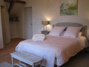 a bedroom with a large bed with white sheets and pillows at Chambres d’Hôtes La Chance au Roy in Aigneville