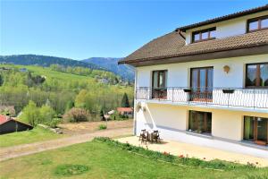 een huis met een balkon en uitzicht op het landschap bij Gîte de famille dans les Vosges in Saint-Maurice-sur-Moselle