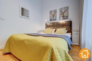 ミエンジズドロイェにあるApartamenty Aquamarina - visitoplのベッドルーム1室(大型ベッド1台、黄色い毛布付)