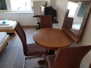 Habitación con mesa, sillas y espejo. en Vándor Szálló, en Kecskemét