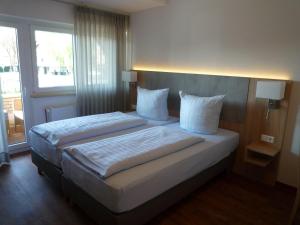 a bedroom with two beds and a large window at Hotel - Restaurant Veldscholten in Lingen