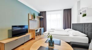 een woonkamer met een bank en een televisie bij HONEST Smichov in Praag