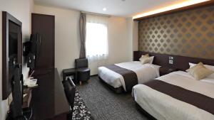 Shinhidaka的住宿－安尼克斯酒店，酒店客房设有两张床和电视。