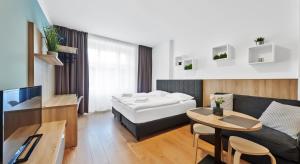 une chambre d'hôtel avec un lit, un canapé et une table dans l'établissement HONEST Smichov, à Prague