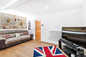 uma sala de estar com um sofá e uma televisão em Modern, Chic 3BR Townhouse in Central Oxford em Oxford