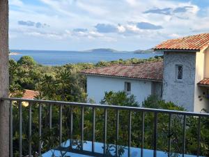 a view of the ocean from the balcony of a house at Résidence les pieds dans l'eau in Porto-Vecchio
