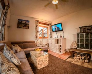 a living room with a couch and a tv at Ferienwohnung Wörnerblick in Mittenwald